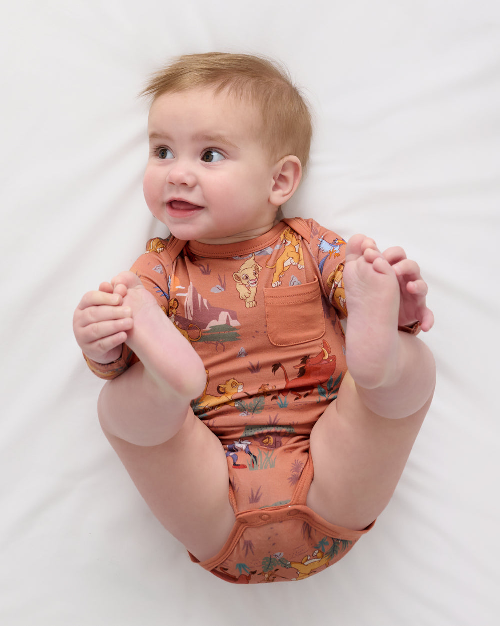 Alternate aerial view of baby wearing the Disney Simba's Safari Pocket Bodysuit