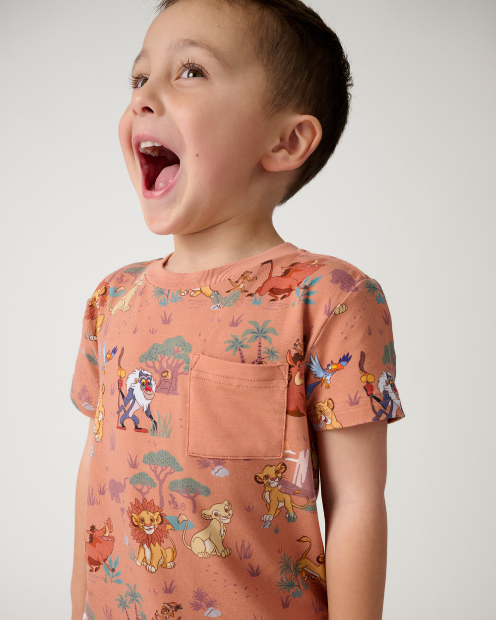 Close up of boy wearing the Disney Simba's Safari Relaxed Pocket Tee