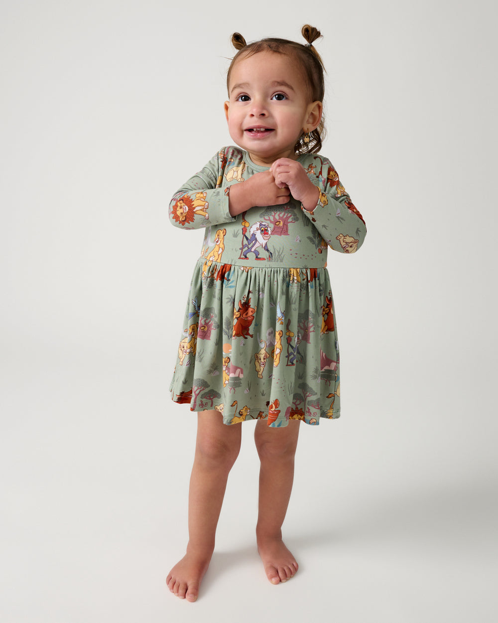 Standing toddler wearing the Disney Simba's Safari Skater Dress with Bodysuit