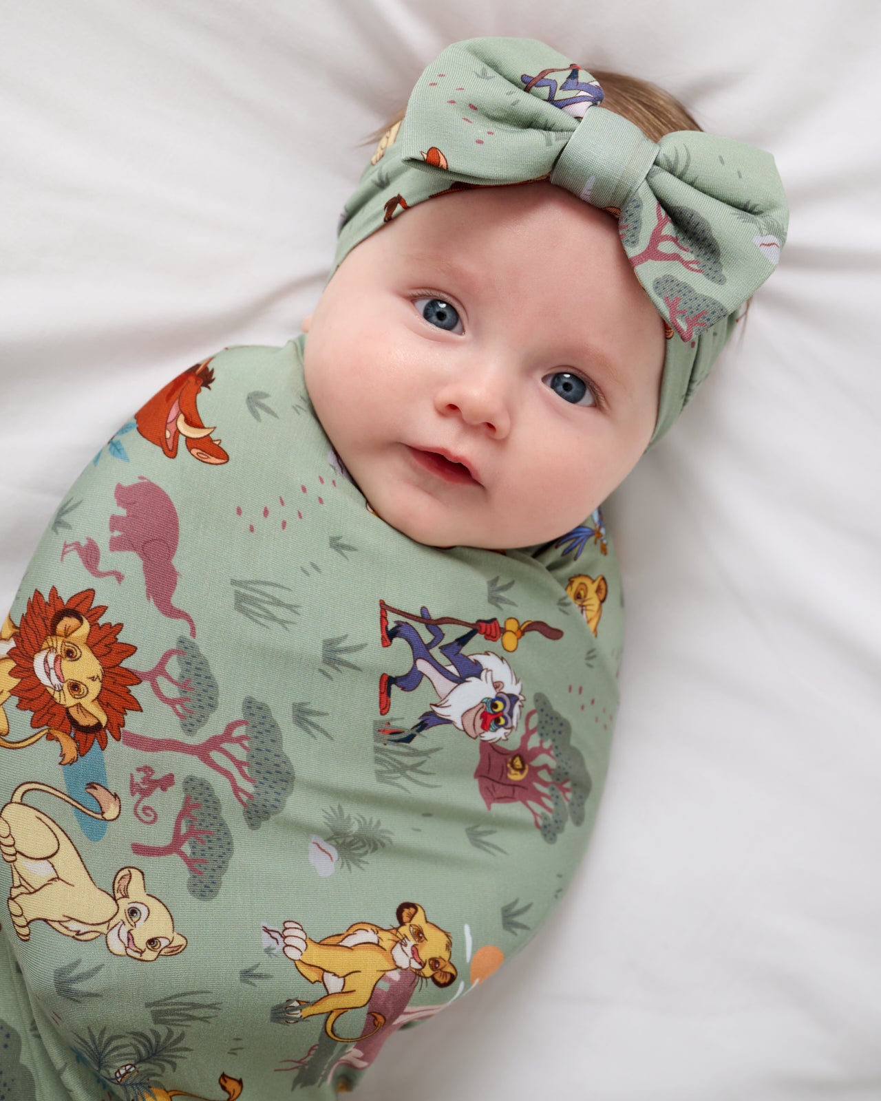 Close up of baby wearing the Disney Simba's Safari Swaddle & Luxe Bow Headband Set