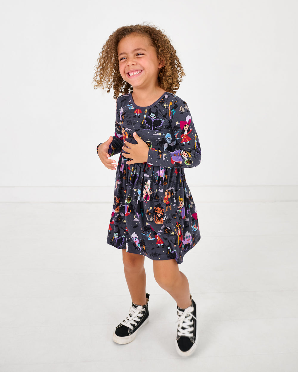 Child wearing the Disney Villains Skater Dress with black sneakers