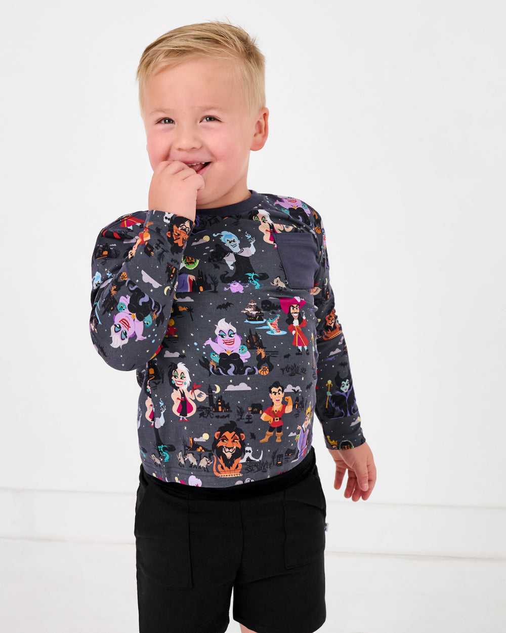 Boy wearing the Disney Villains Long Sleeve Relaxed Pocket Tee with black shorts