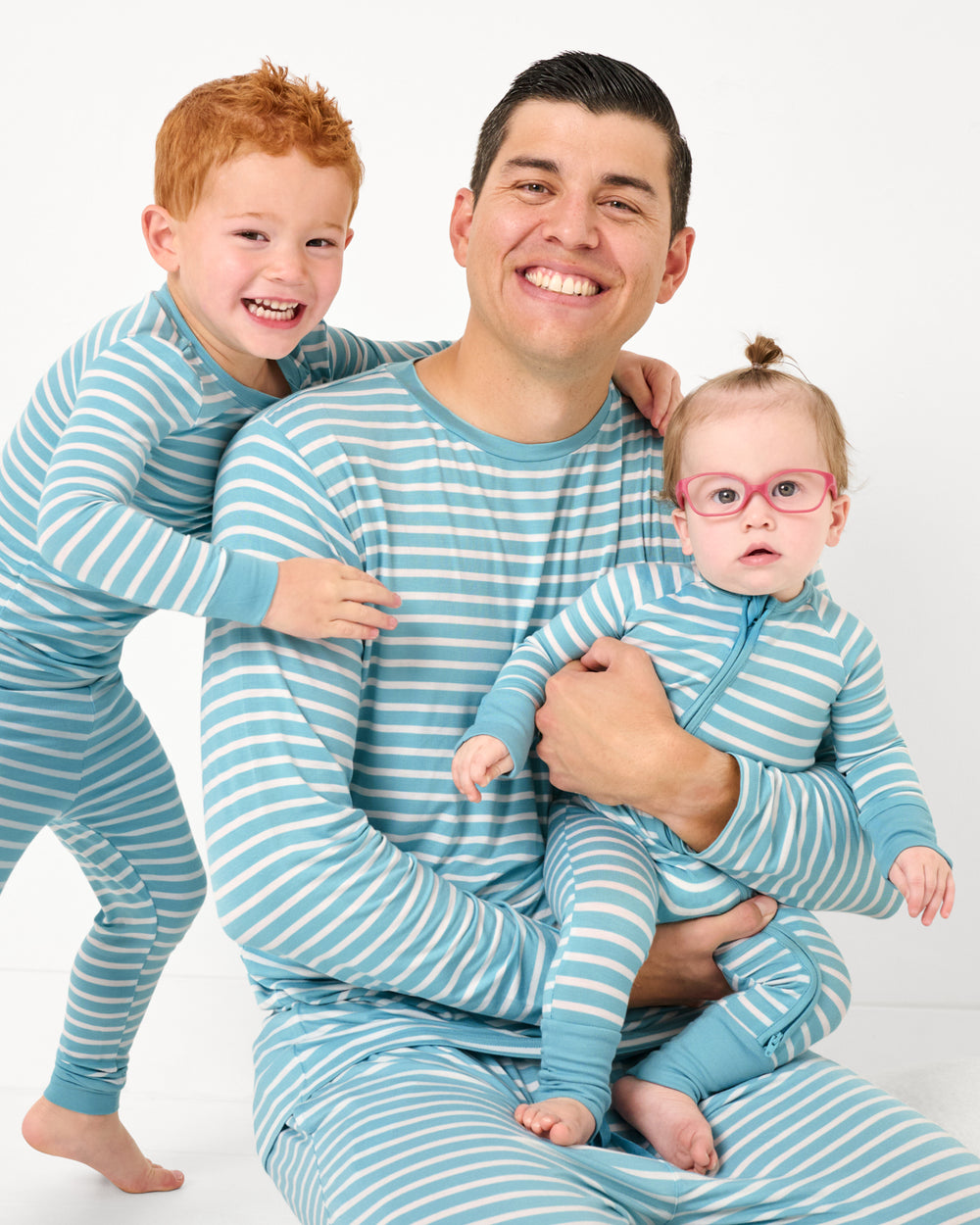 Father and two children wearing matching Dockside Stripe pajamas