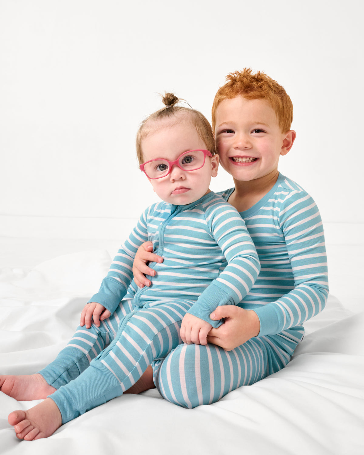Two children wearing matching Dockside Stripe Pajamas