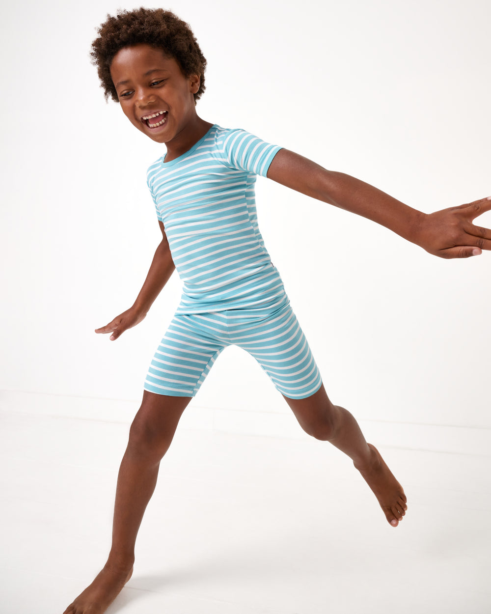 Child in motion wearing the Dockside Stripe Two-Piece Short Sleeve & Shorts Pajama Set