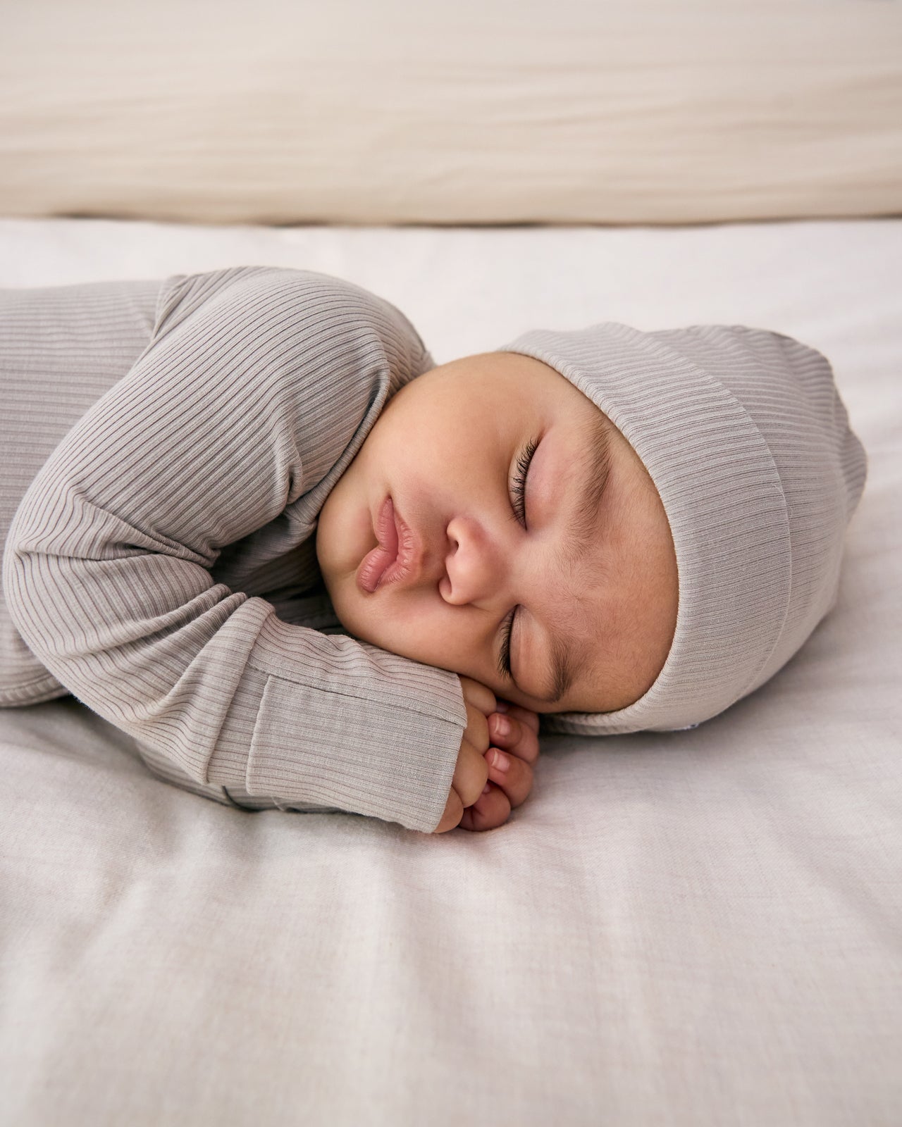 Sleeping baby wearing the Dove Gray Ribbed Infant Beanie
