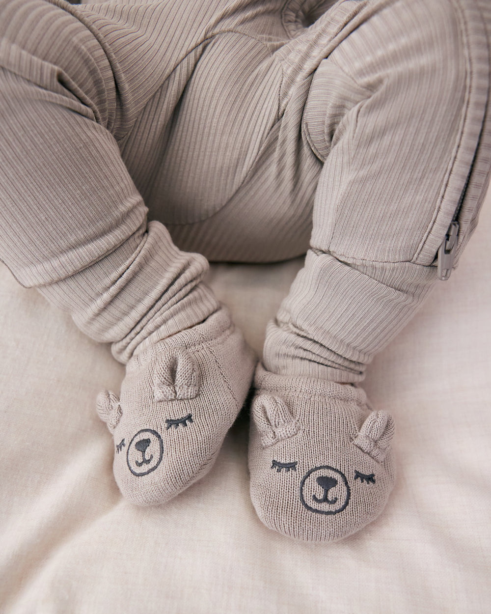 Newborn wearing the Dove Gray Bear Booties with a ribbed zippy