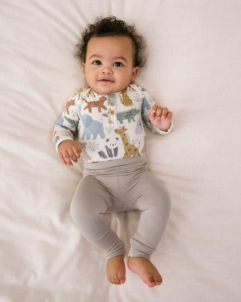 Newborn laying on a white blanket wearing the Dove Gray Fold-Over Legging