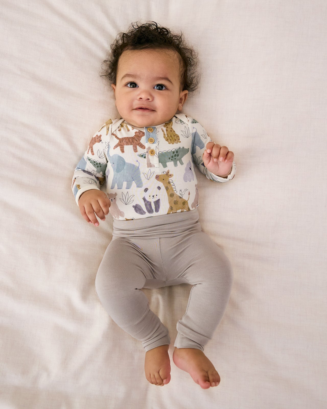 Newborn laying on a white blanket wearing the Dove Gray Fold-Over Legging