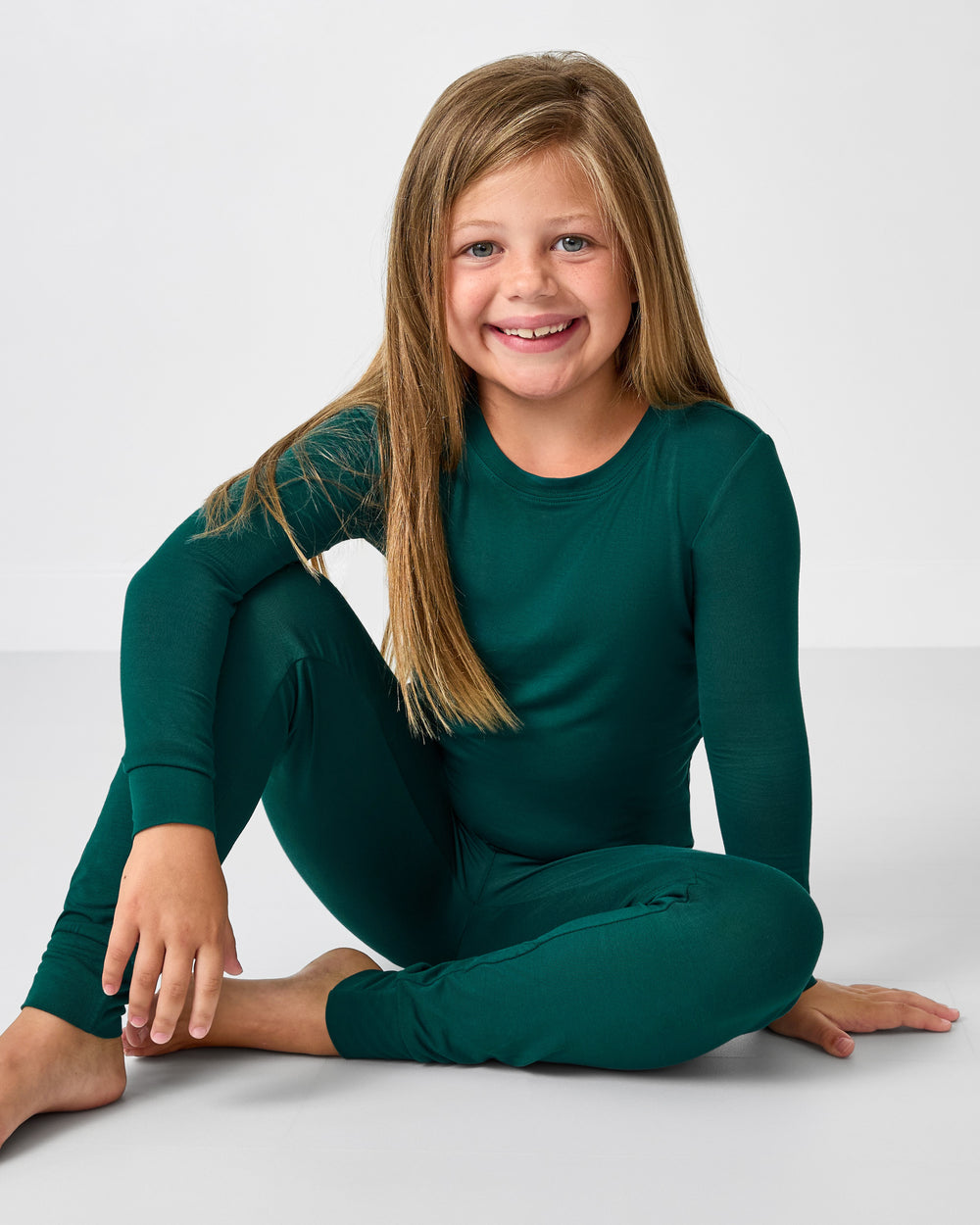 Sitting girl wearing the Emerald Two-Piece Pajama Set