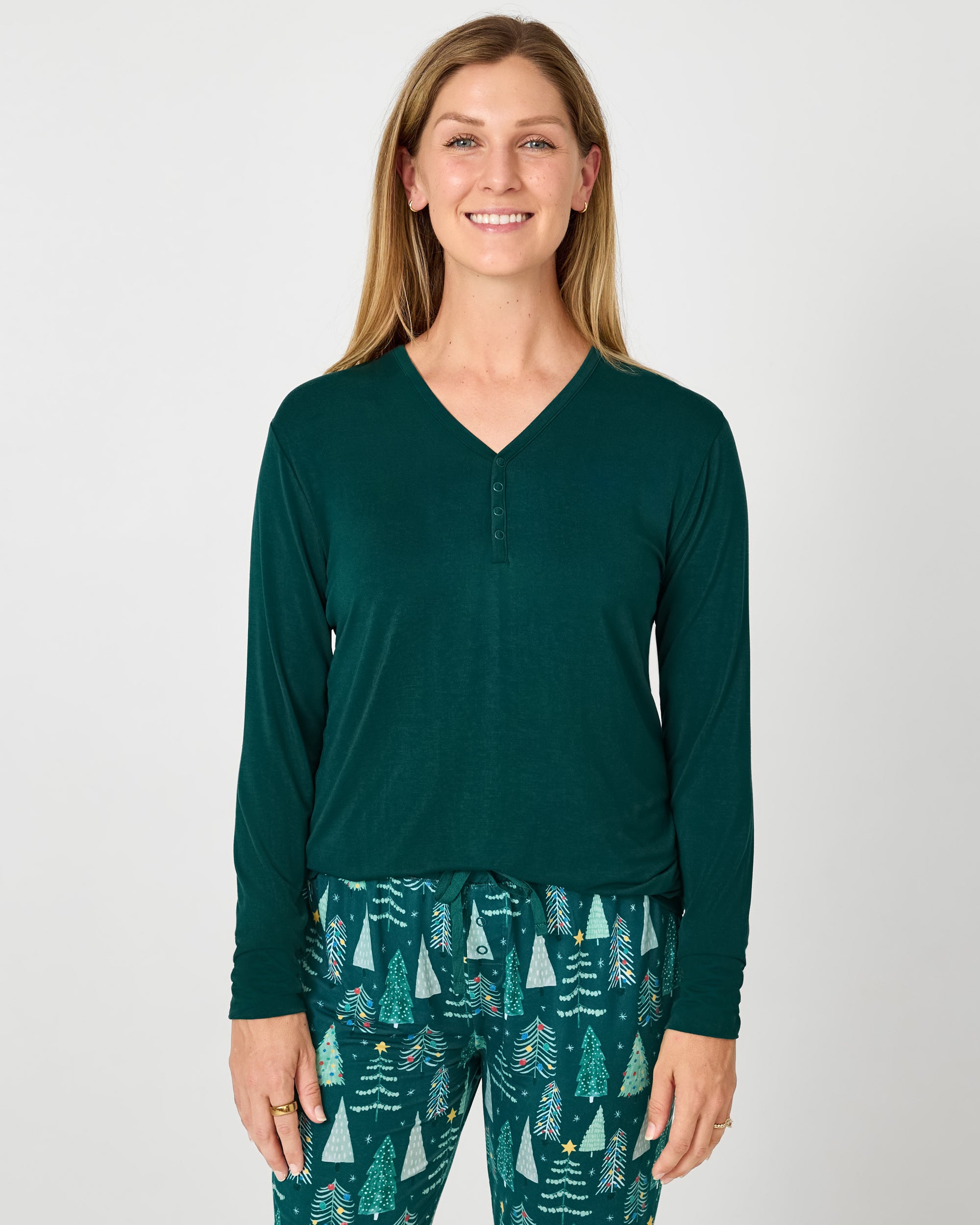 Woman wearing the Emerald Women's Long Sleeve Pajama Top with Twinkling Trees pajama pants