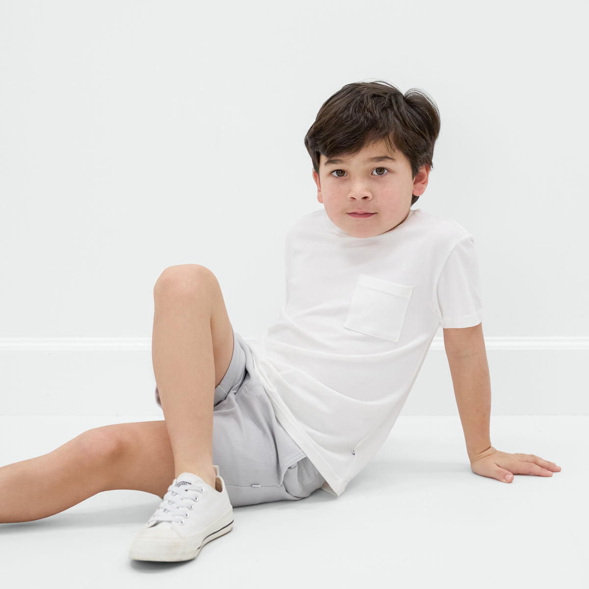 Sitting child wearing the Earl Gray chino shorts with a bright white tee