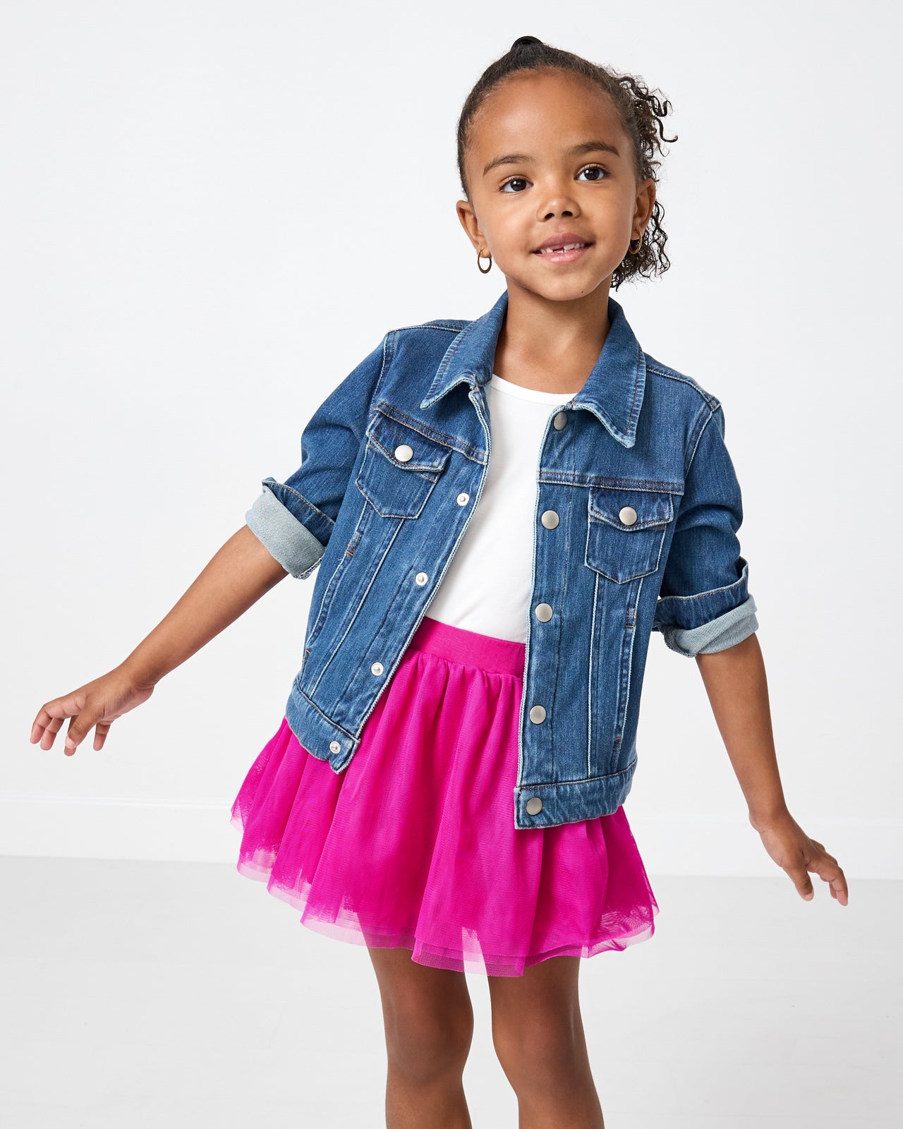 Posing girl wearing the Electric Fuchsia Tutu Skirt with a kids denim jacket