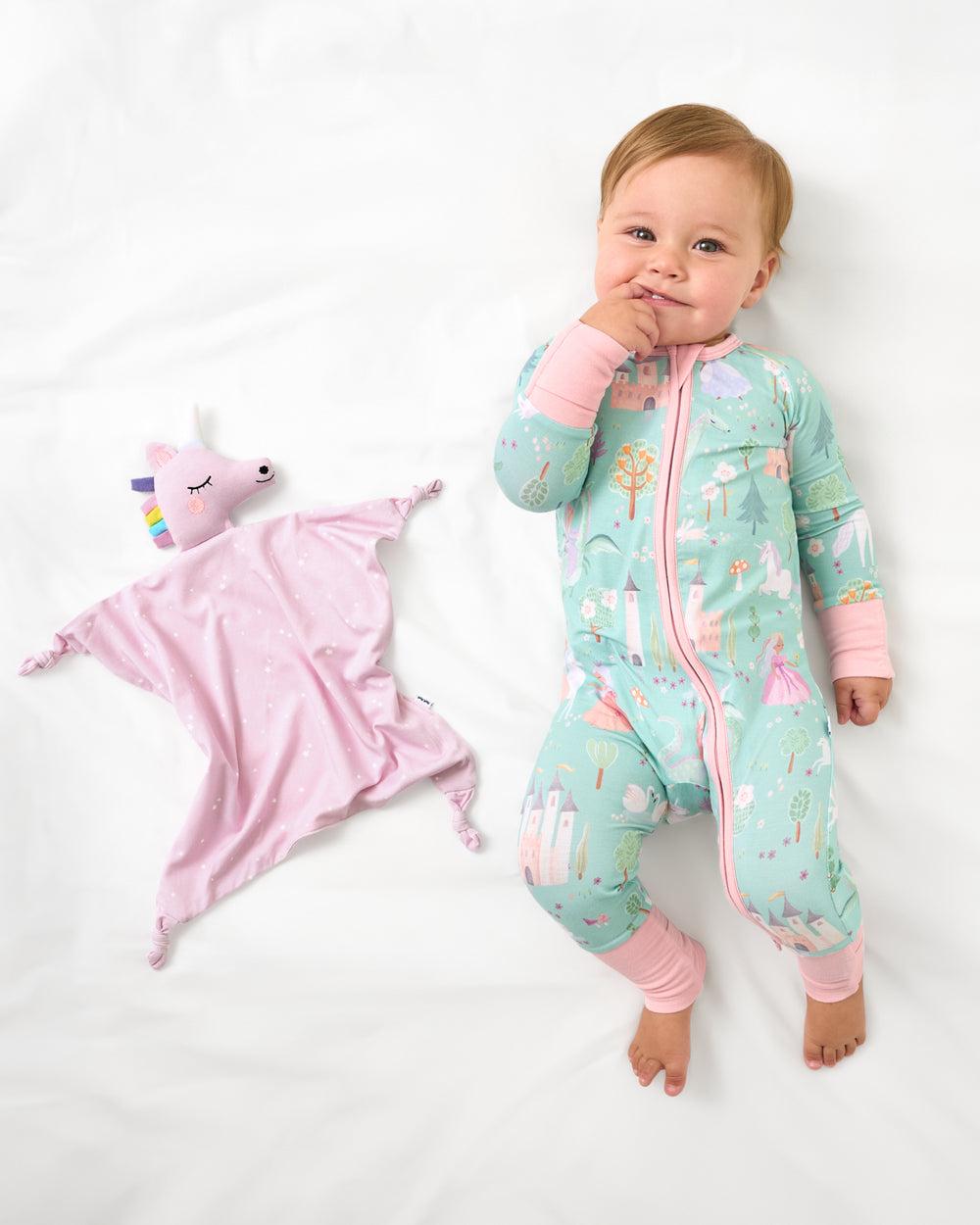 Aerial view of baby laying with the Sienna the Unicorn Sleepyhead Lovey