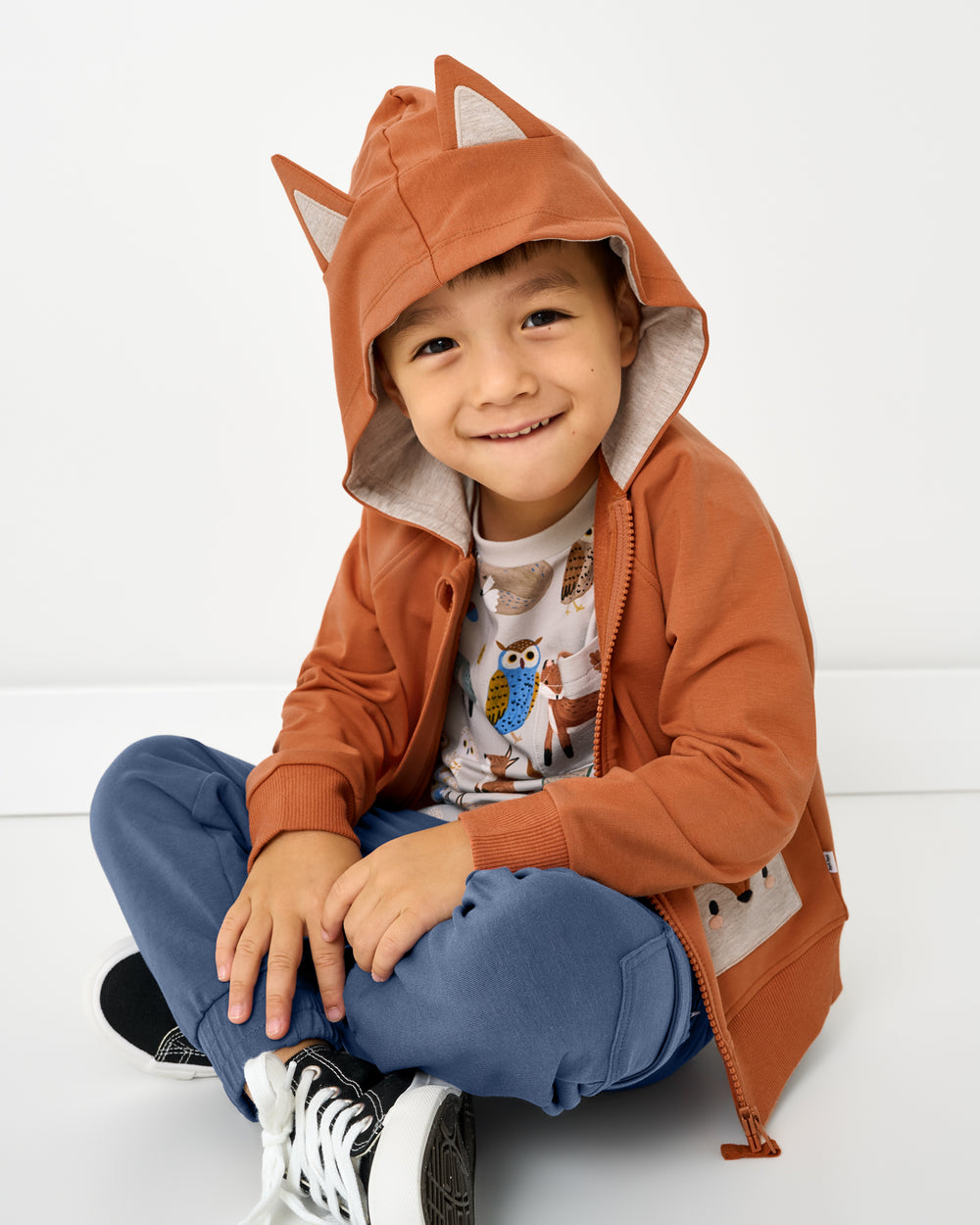 Sitting boy wearing the Fox Zip Hoodie