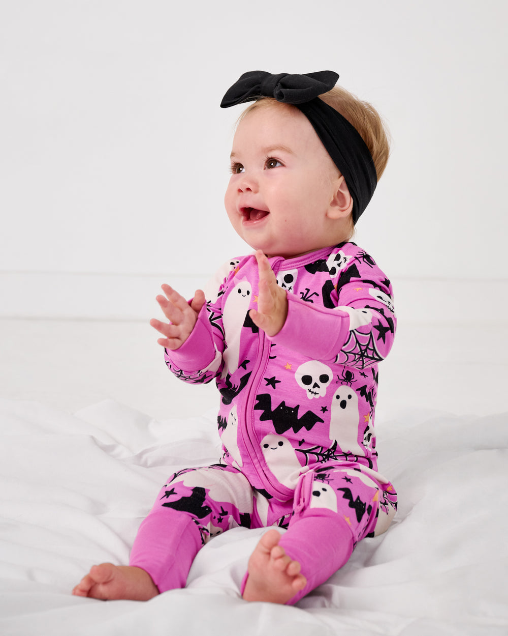 Sitting baby wearing the Pink Frightful Friends Zippy