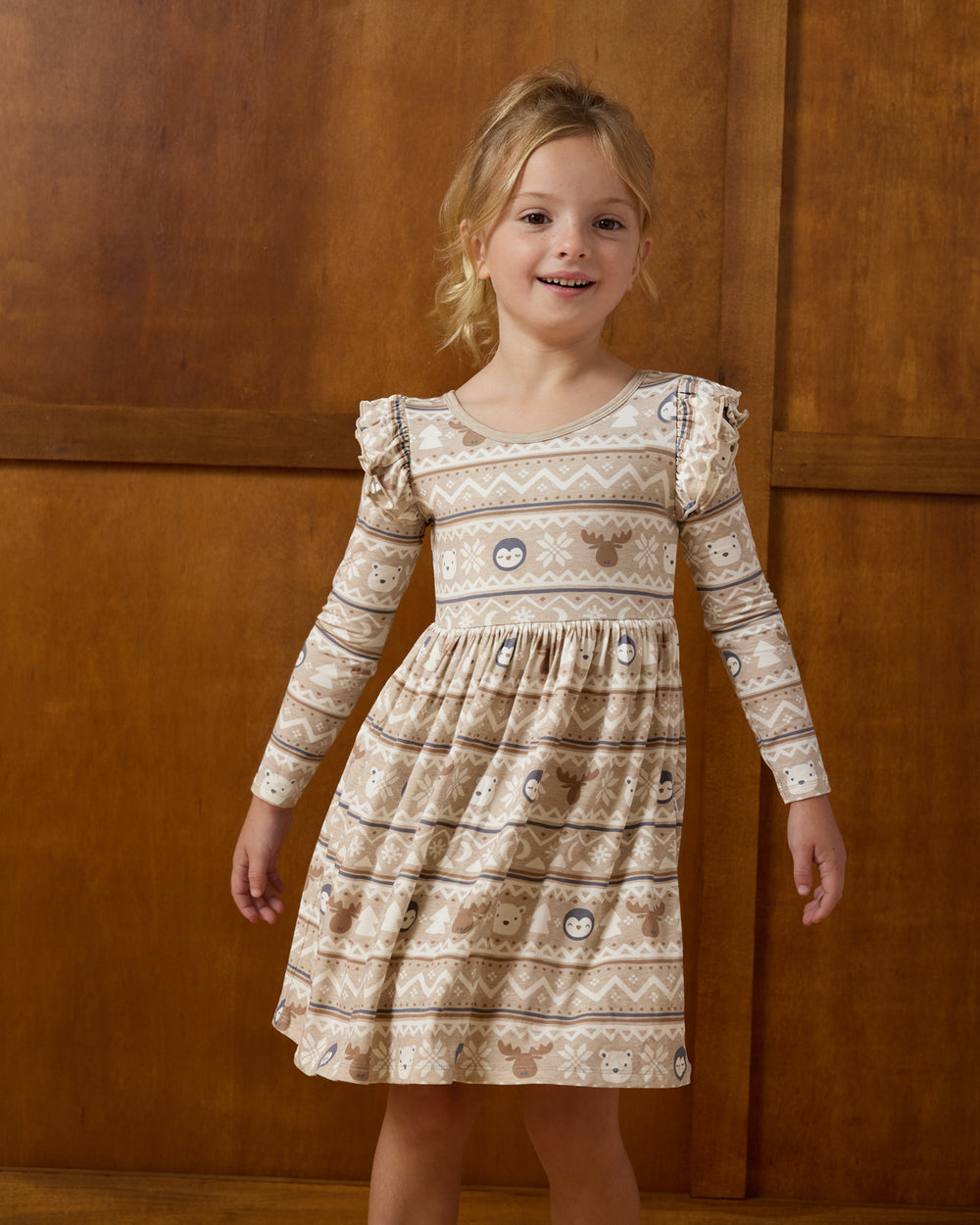Girl wearing the Frosty Fair Isle Flutter Skater Dress on a brown background