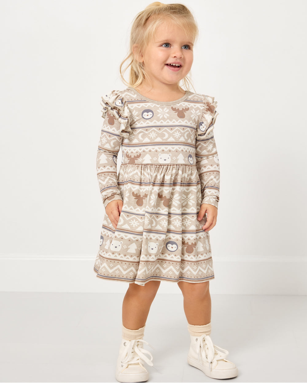 Girl wearing the Frosty Fair Isle Flutter Skater Dress with white sneakers