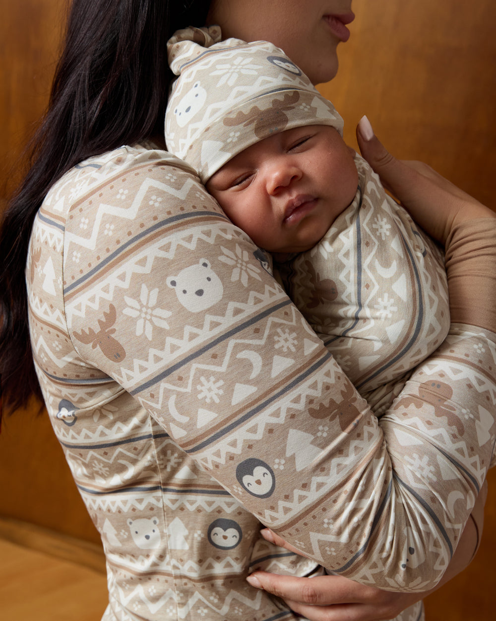 Mother holding baby wearing the Frosty Fair Isle Swaddle & Hat Set