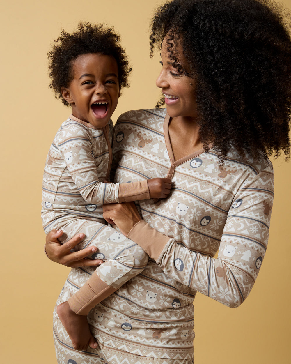 Mother and child wearing matching Frosty Fair Isle pajamas on a yellow background