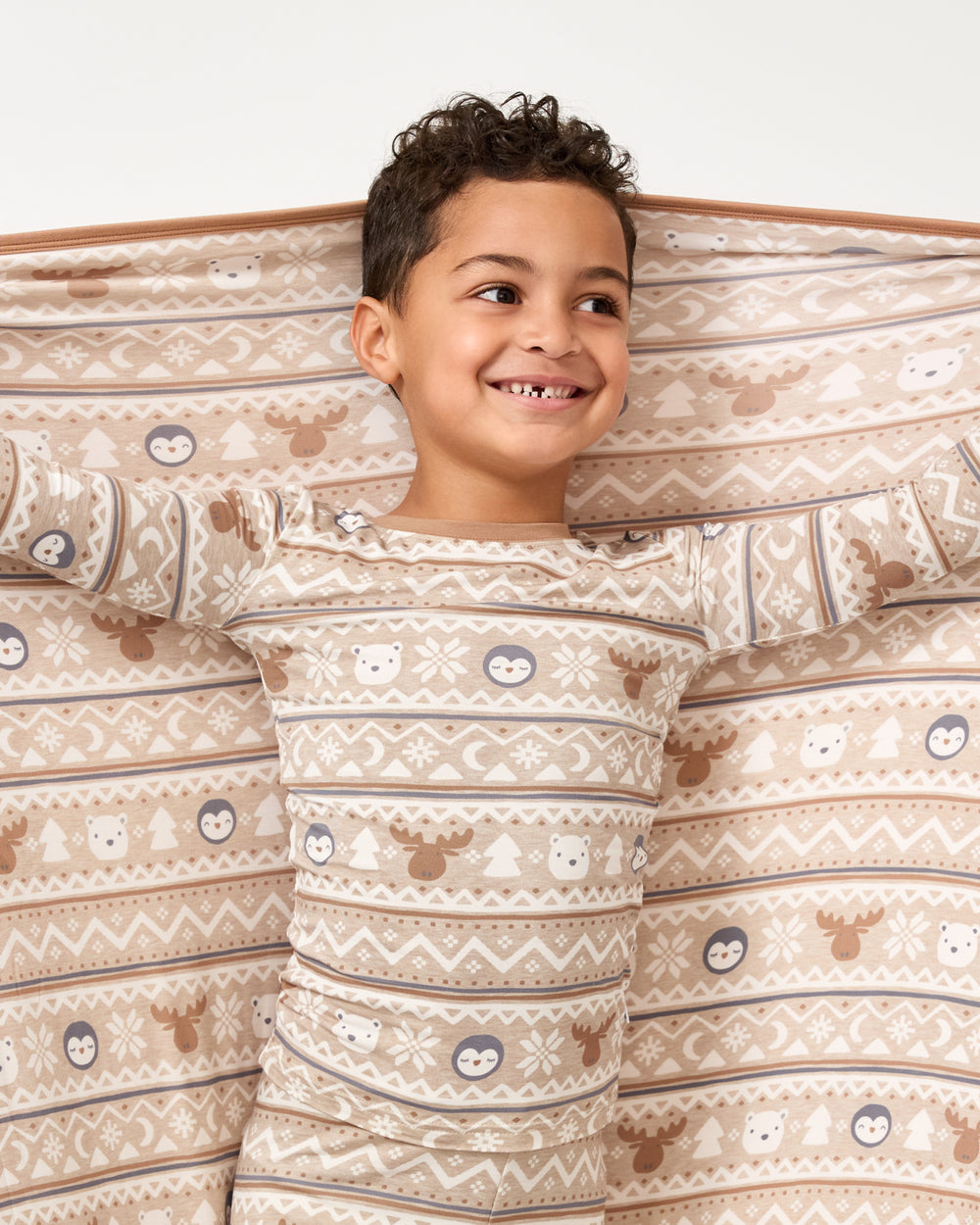 Boy holding up the Frosty Fair Isle Large Cloud Blanket®