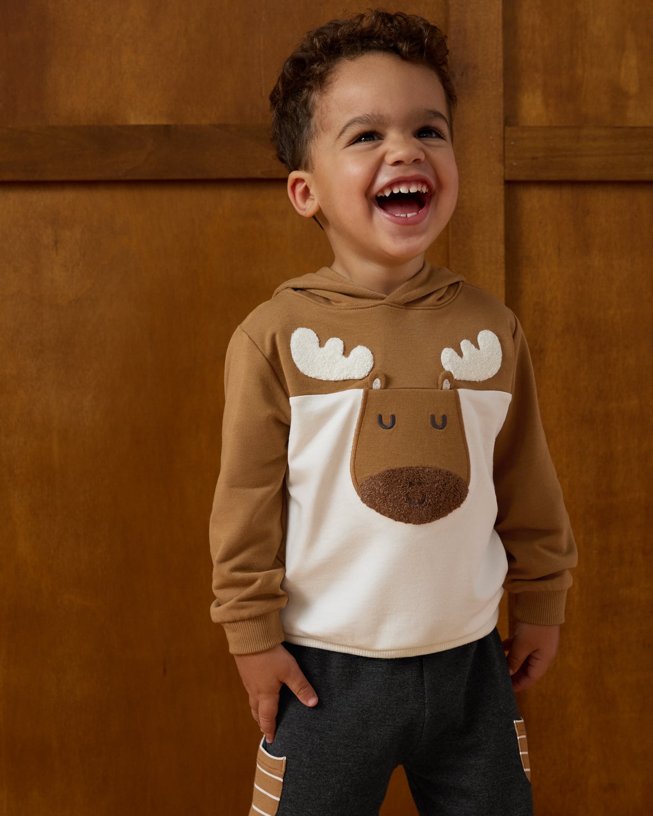 Boy wearing the Moose Pullover Hoodie on a brown background