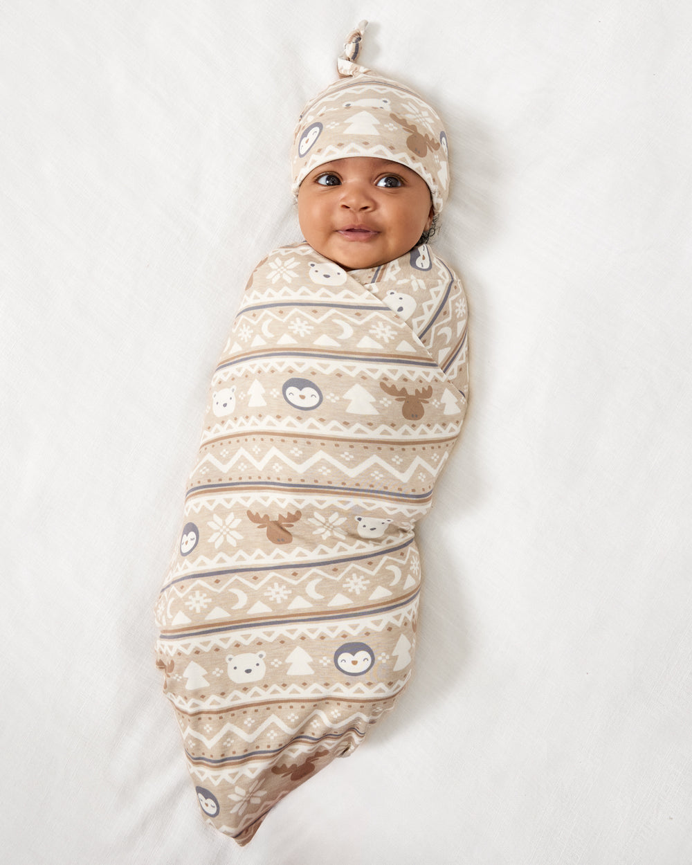 Aerial view of baby wearing the Frosty Fair Isle Swaddle & Hat Set