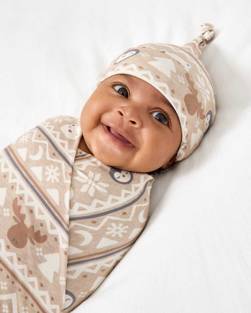 Close up of baby wearing the Frosty Fair Isle Swaddle & Hat Set