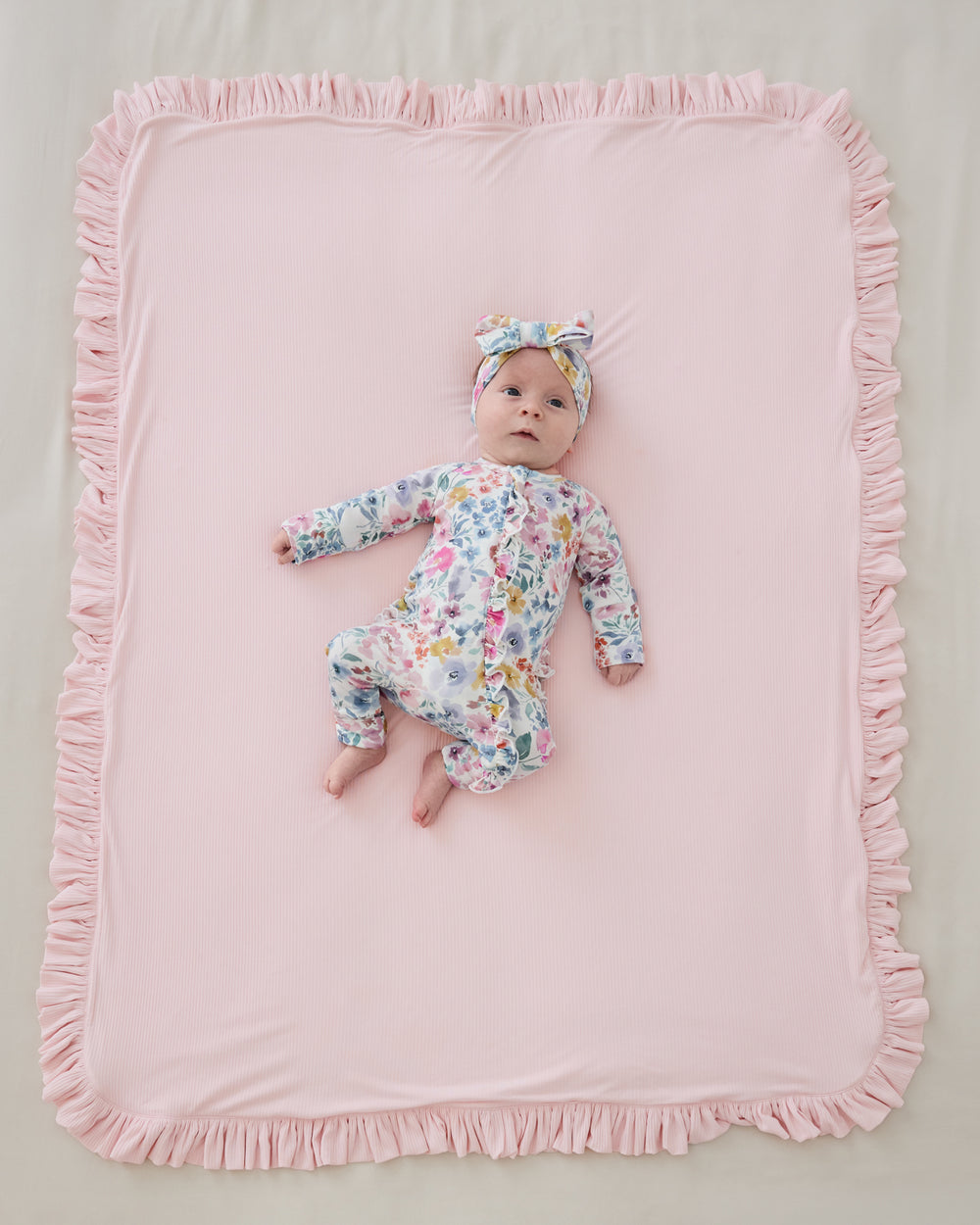 Aerial view of baby laying on the pink side  the Prima Pink Ribbed Ruffle Mini Cloud Blanket®