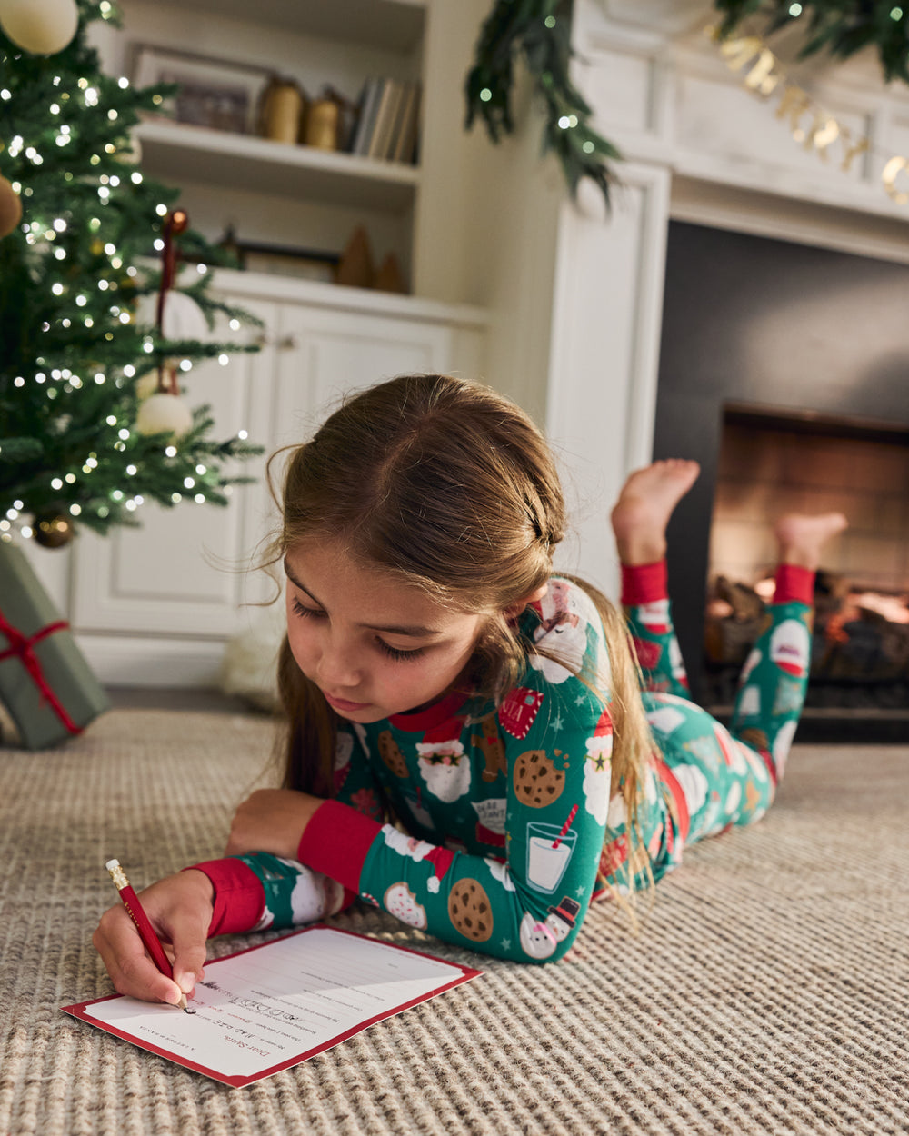 Girl in a festive room wearing the Cookies for Santa Two-Piece Pajama Set