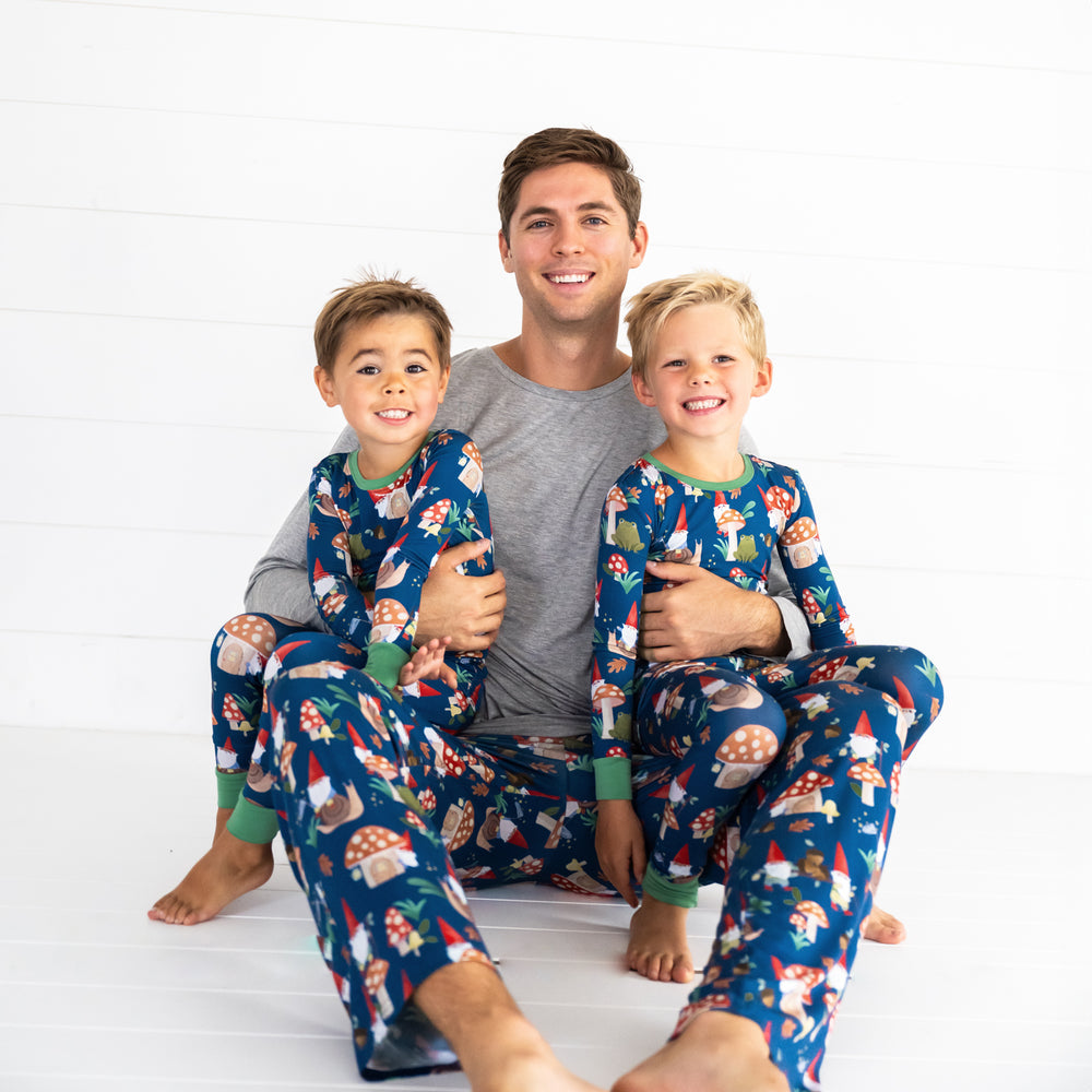 Family of three in the Forest Gnomes print. Male model in the middle is wearing the Forest Gnomes Men's Pajama Pant and two boys on the left and right are in the Forest Gnomes Two-piece Pajama Set