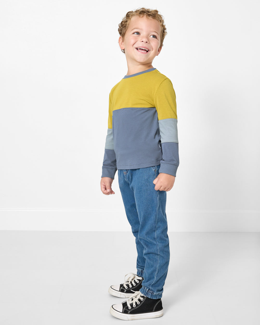 Boy wearing the Golden Moss Paneled Tee with denim pants