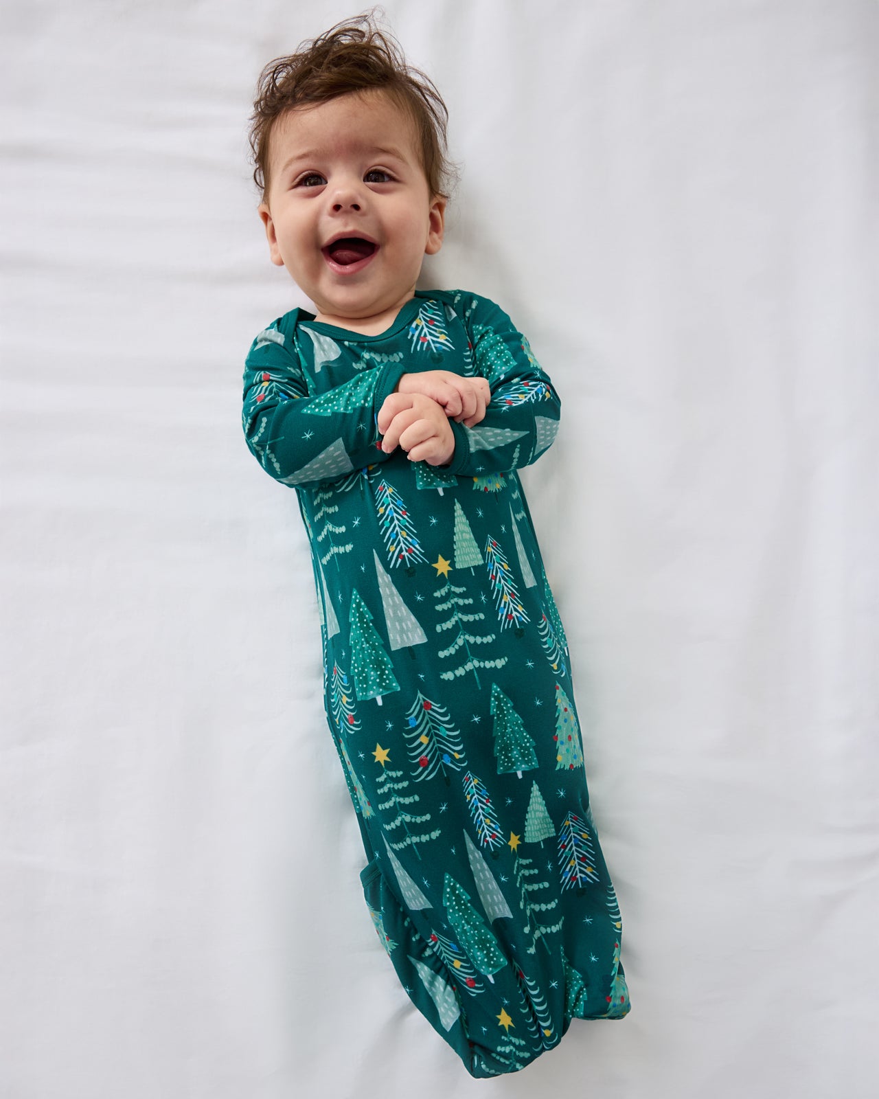 Aerial view of baby wearing the Twinkling Trees Infant Gown