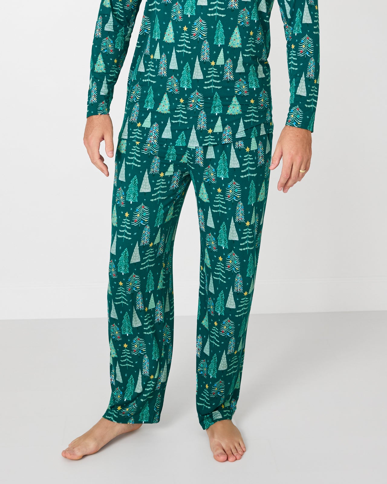 Man wearing the Twinkling Trees Men's Pajama Pants with a coordinating pajama top