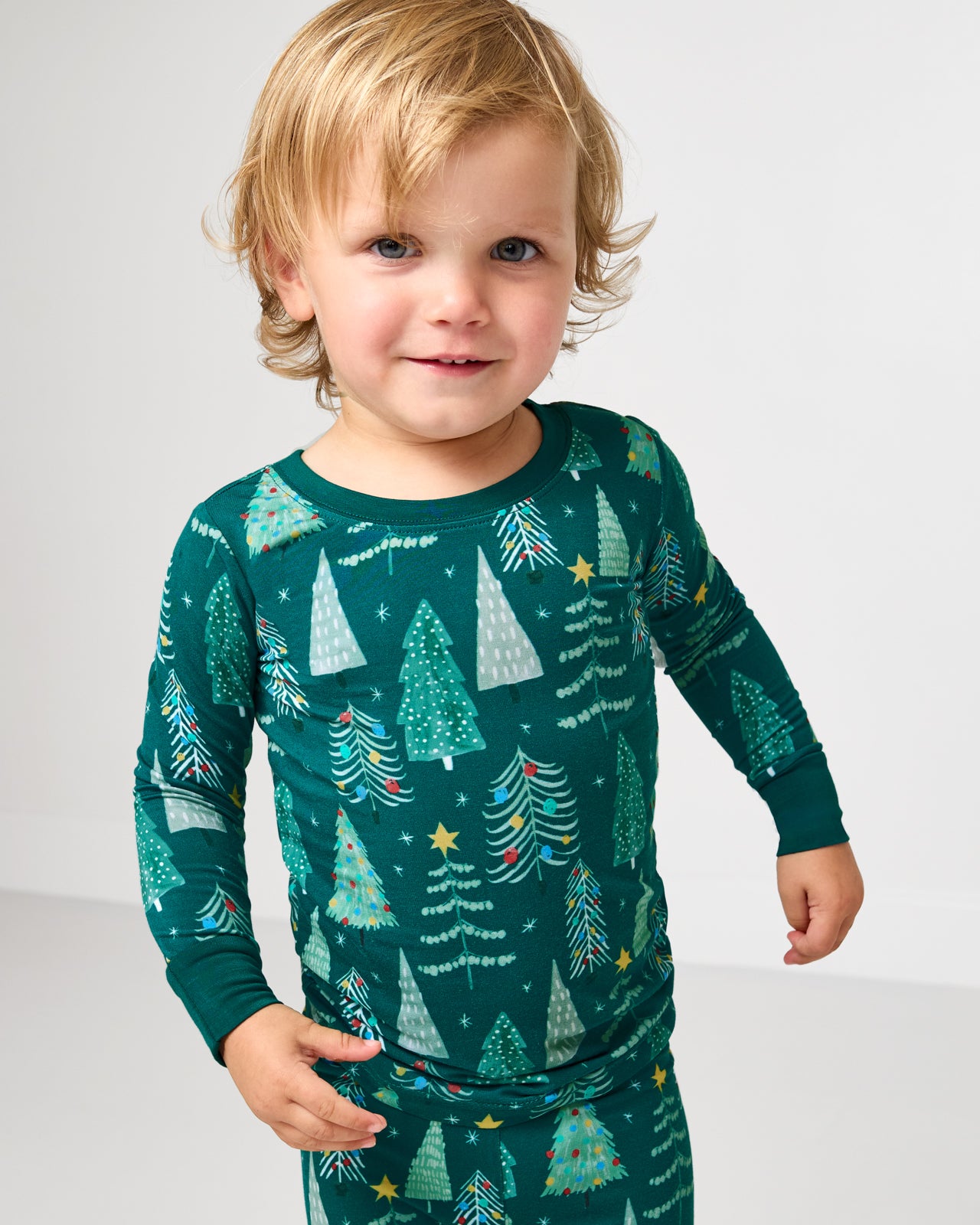 Close up of child wearing the Twinkling Trees Two-Piece Pajama Set