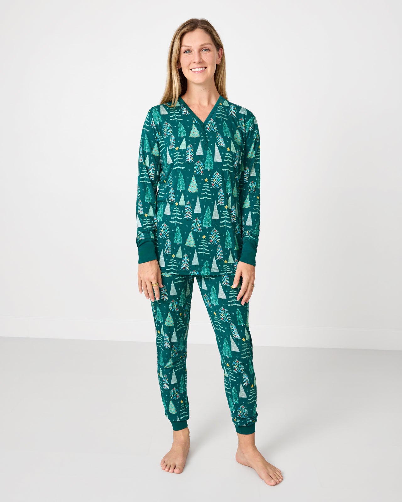 Woman wearing the Twinkling Trees Women's Pajama Pants with a coordinating pajama top