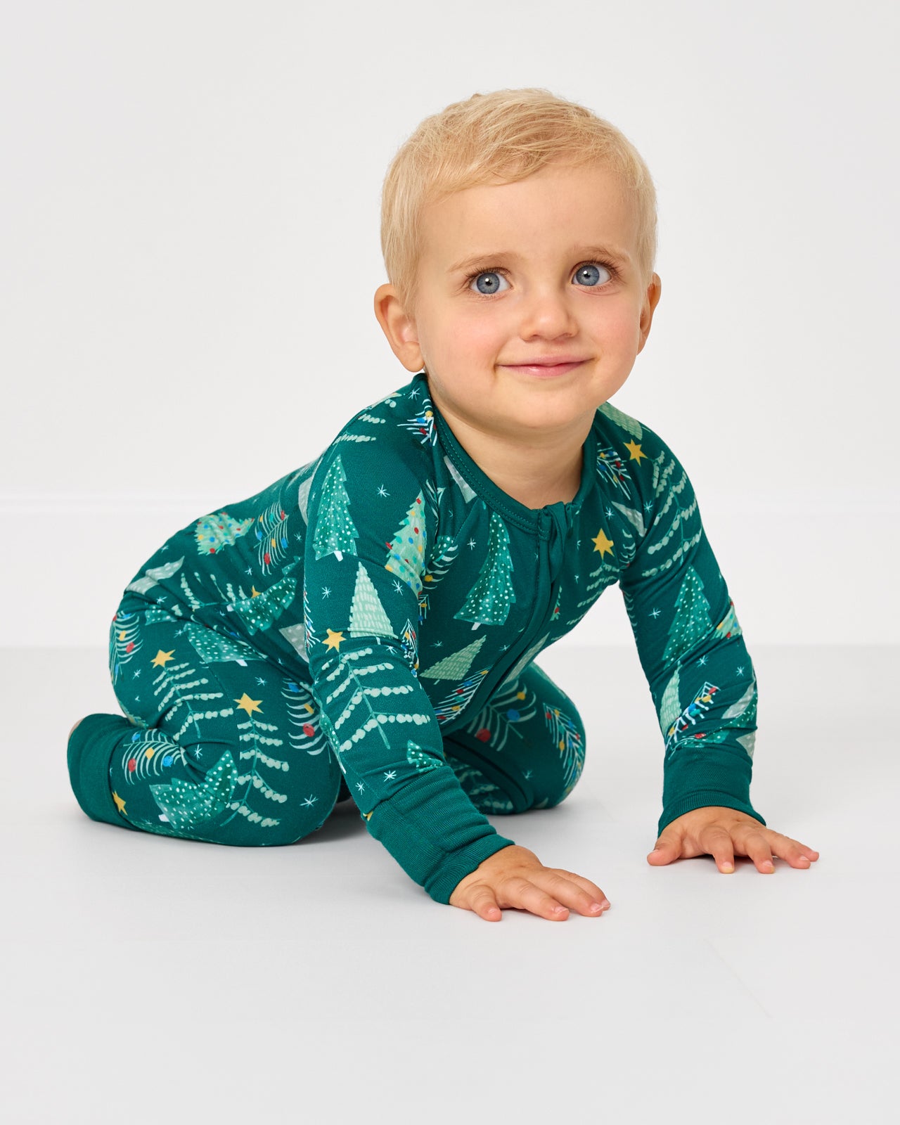 Crawling baby wearing the Twinkling Trees Zippy