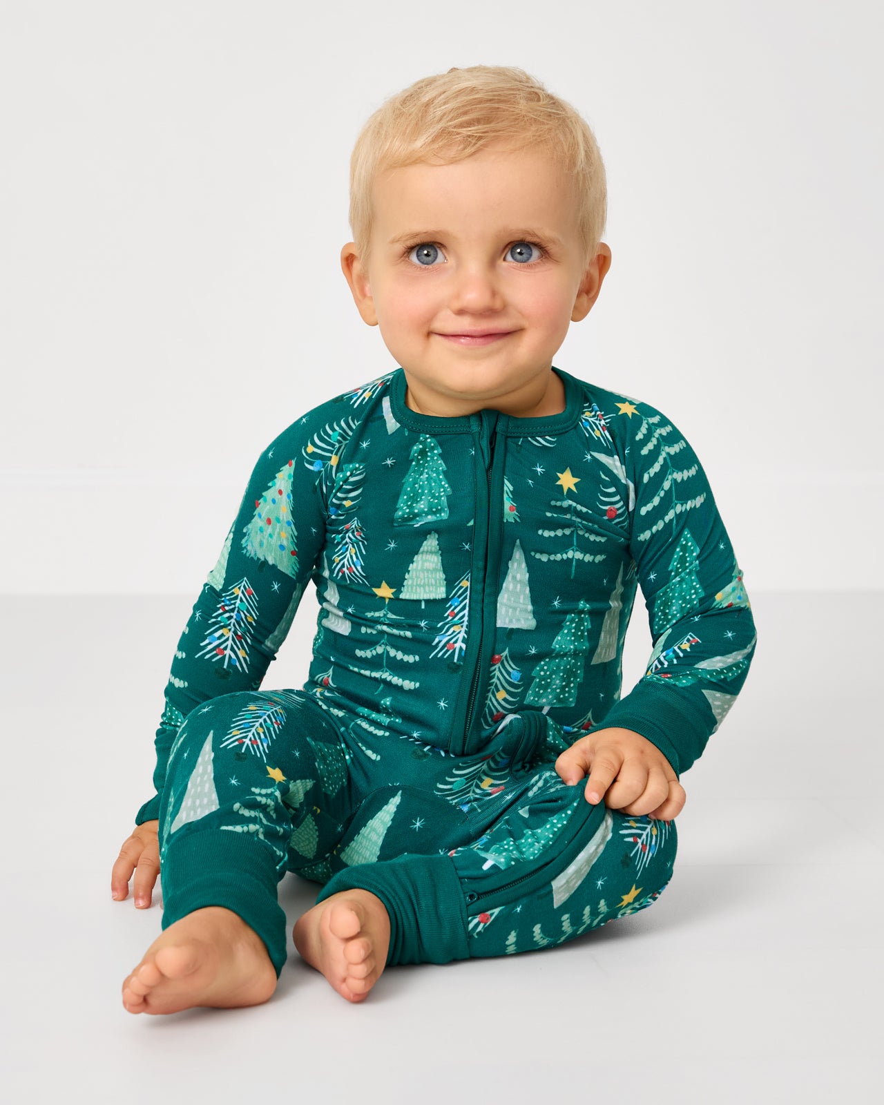 Sitting baby wearing the Twinkling Trees Zippy