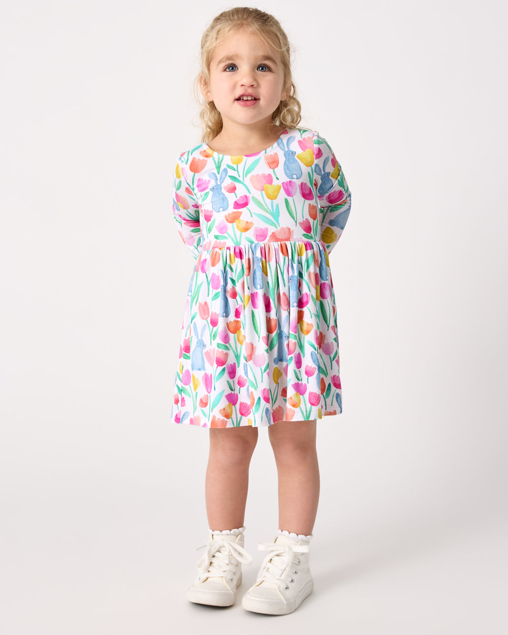 Girl wearing the Garden Hop Bow Back Skater Dress with white sneakers