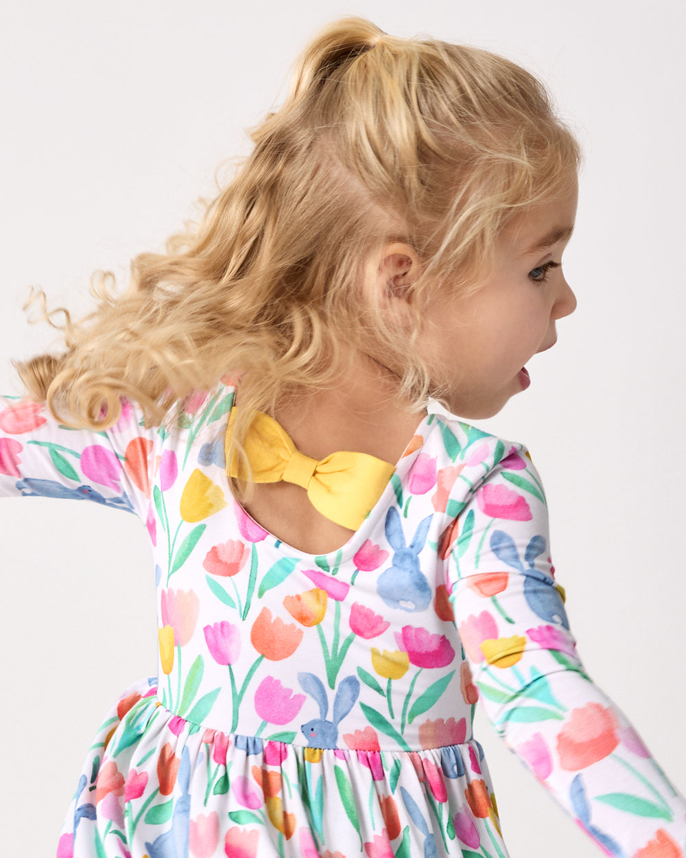 Back view of child wearing the Garden Hop Bow Back Skater Dress