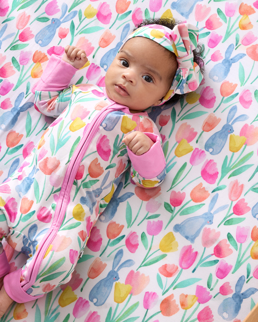 Baby laying on the Garden Hop Fitted Crib Sheet