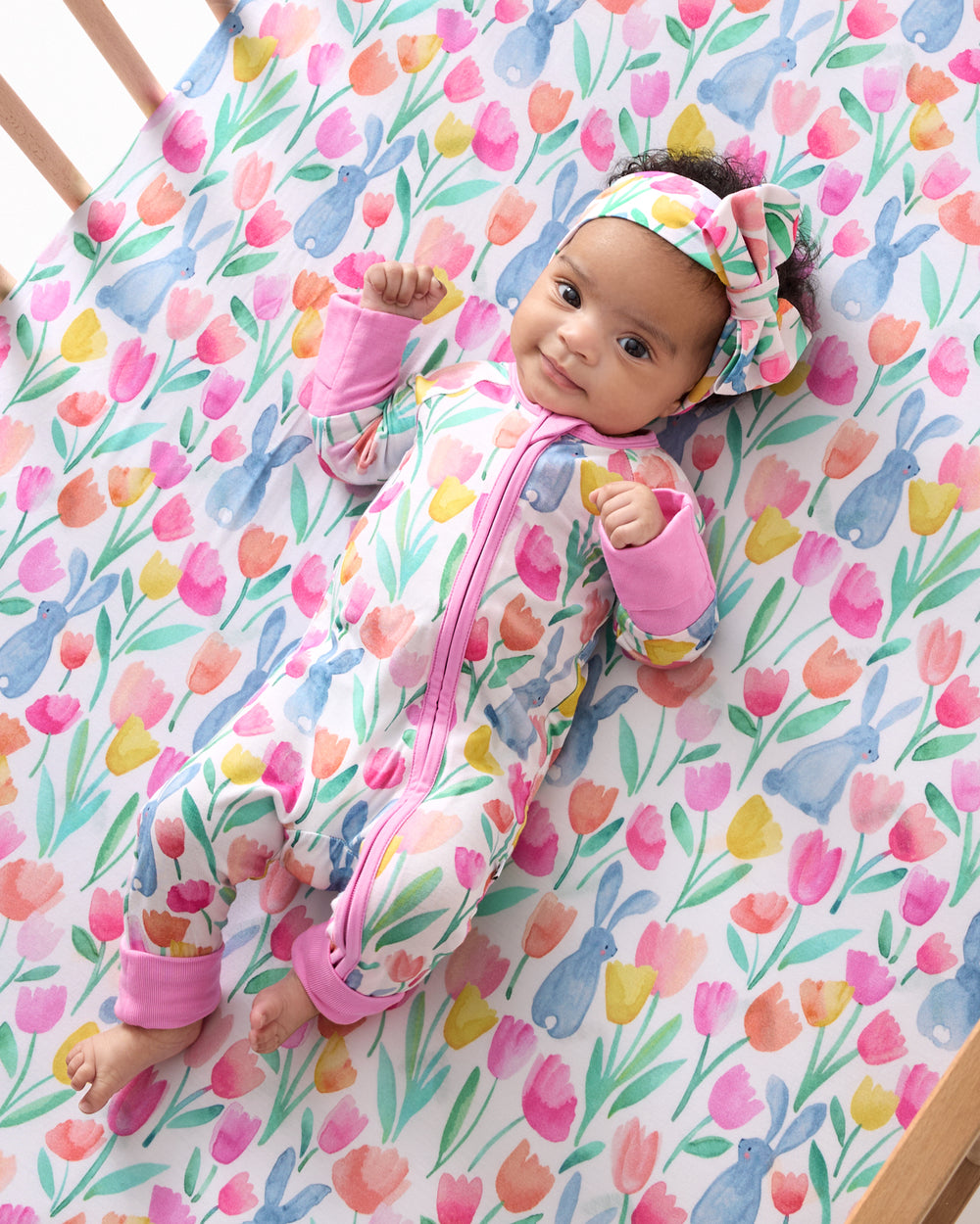 Aerial view of baby in a crib with the Garden Hop Fitted Crib Sheet