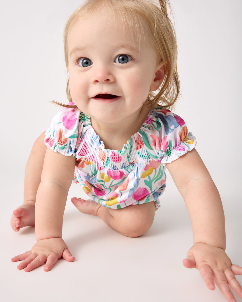 Crawling baby wearing the Garden Hop Smocked Bubble Romper
