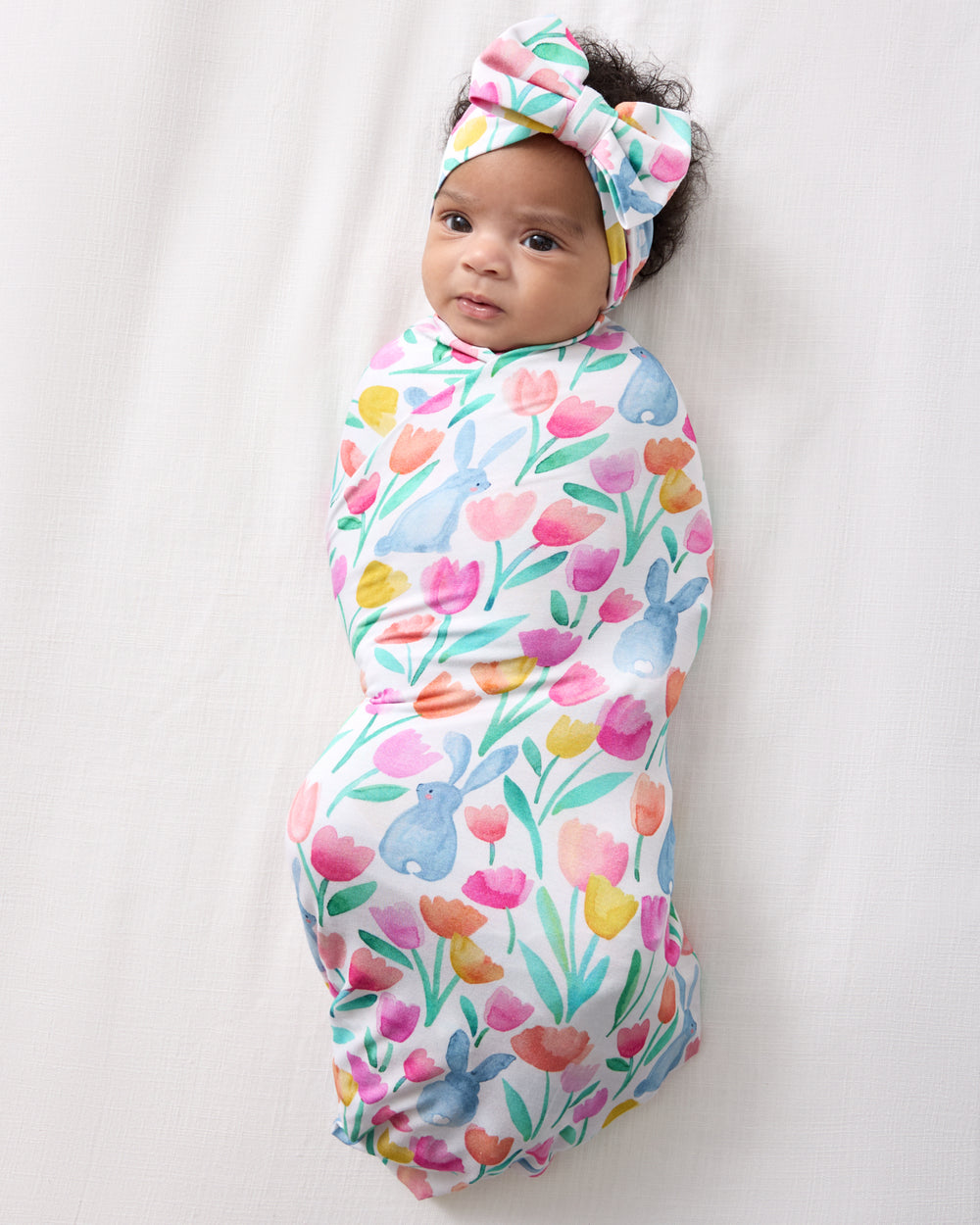 Overhead view of alternate baby in the Garden Hop Swaddle & Luxe Bow Headband Set