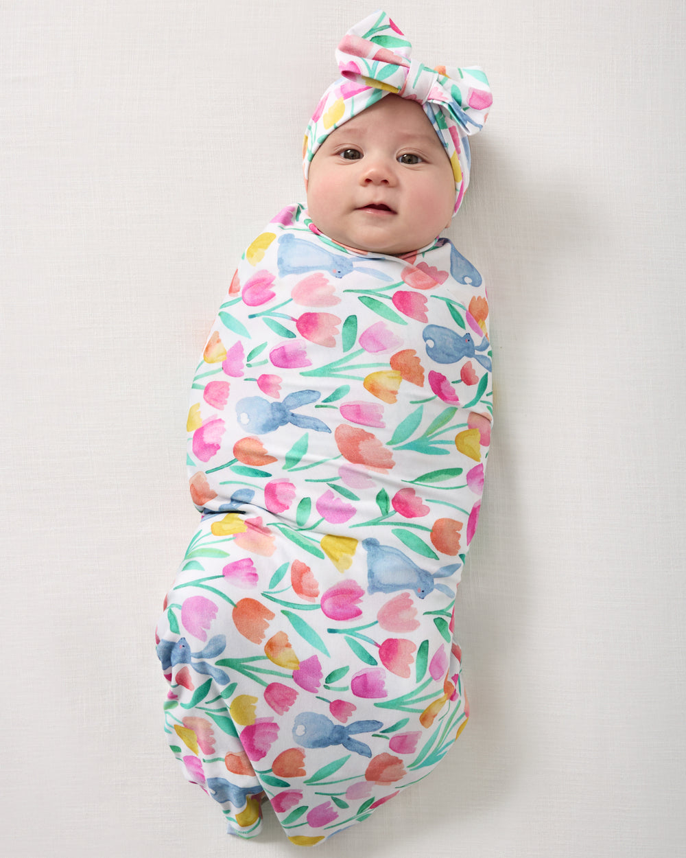 Aerial view of baby in the Garden Hop Swaddle & Luxe Bow Headband Set