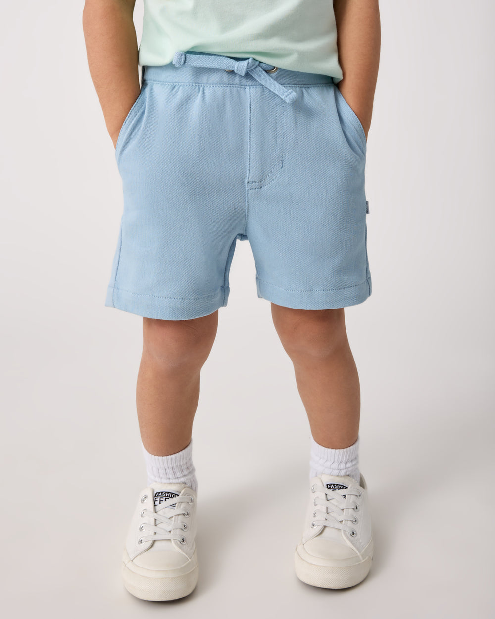 Child wearing the Gentle Blue Chino Shorts with white sneakers