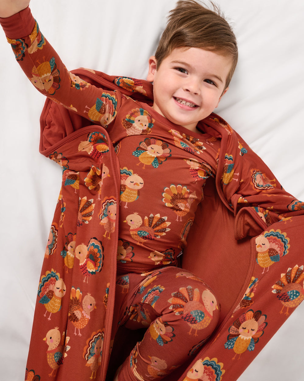 Aerial view of boy wrapped in the Grateful Gobbles Large Cloud Blanket®
