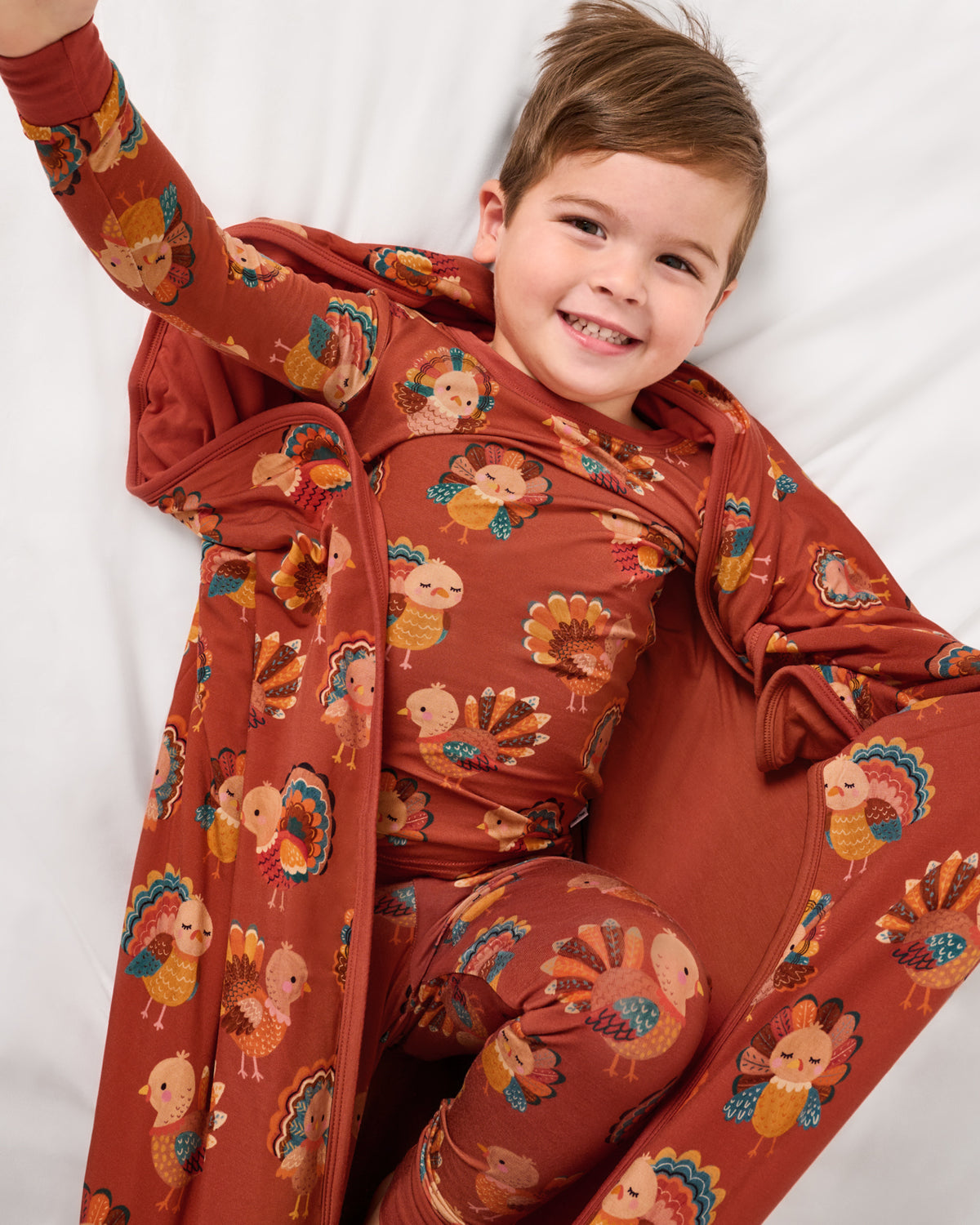Aerial view of boy wrapped in the Grateful Gobbles Large Cloud Blanket®