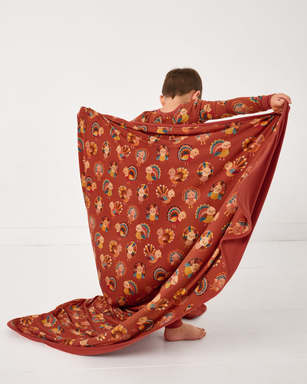 Boy holding up the Grateful Gobbles Large Cloud Blanket®