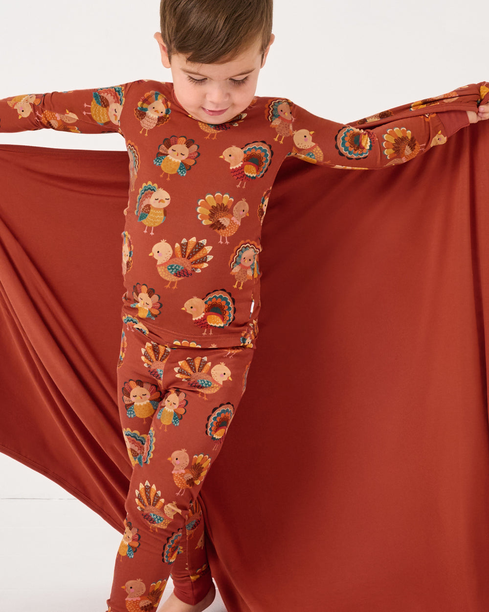 Boy holding up the Grateful Gobbles Large Cloud Blanket® showing the solid side